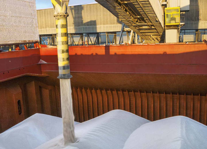 Fertilizer being loaded into the hold of a ship